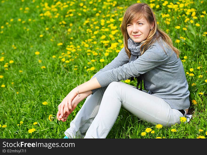 The girl sits on a grass