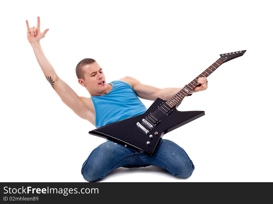 Attractive musician playing guitar on his knees and making a rock and roll gesture over white. Attractive musician playing guitar on his knees and making a rock and roll gesture over white