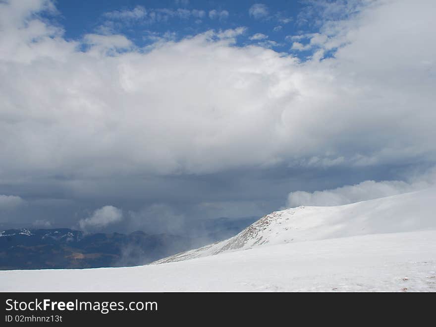 Mountain winter slope in clouds.