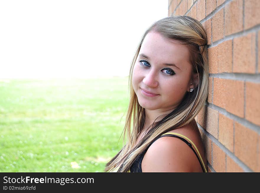 Girl standing next to brick wall