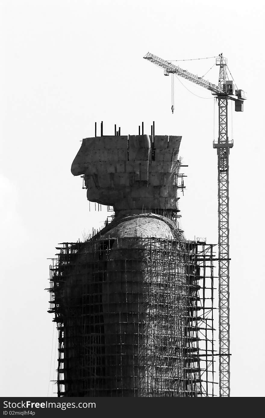 Crane on a high rise construction of big Buddha sculpture Thailand