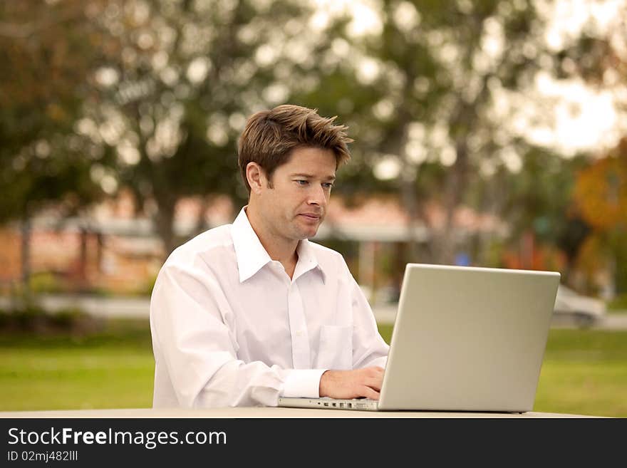 Man looking at his laptop outside. Man looking at his laptop outside