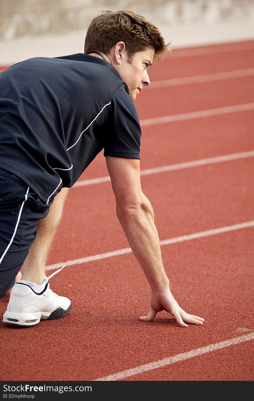 Man getting ready to run on a track. Man getting ready to run on a track