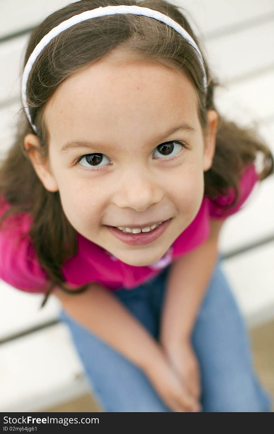 Portrait of a cute little girl on bench