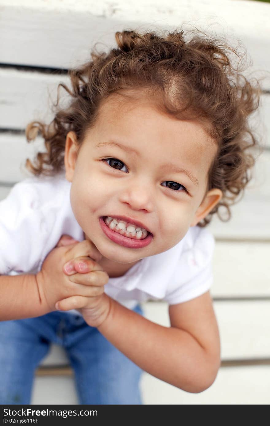 Portrait of a cute little girl on bench