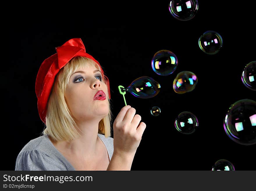 Cute blond girl plays with bubbles in studio. Cute blond girl plays with bubbles in studio