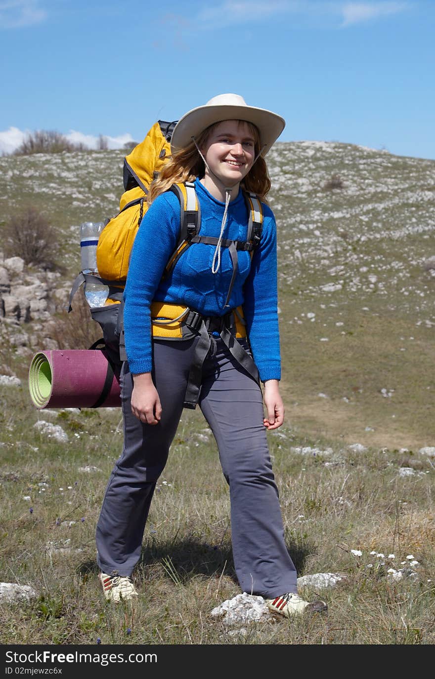 Girl in blue jacket with yellow backpack walking outdoor