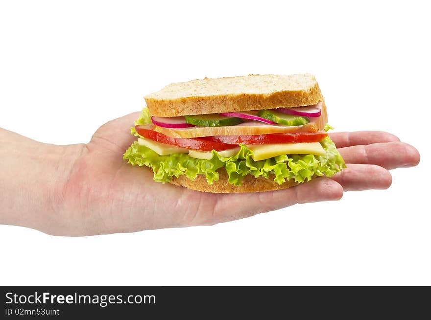 Sandwich with ham, tomato, radish, cucumber and cheese in the hand isolated over white background. Sandwich with ham, tomato, radish, cucumber and cheese in the hand isolated over white background