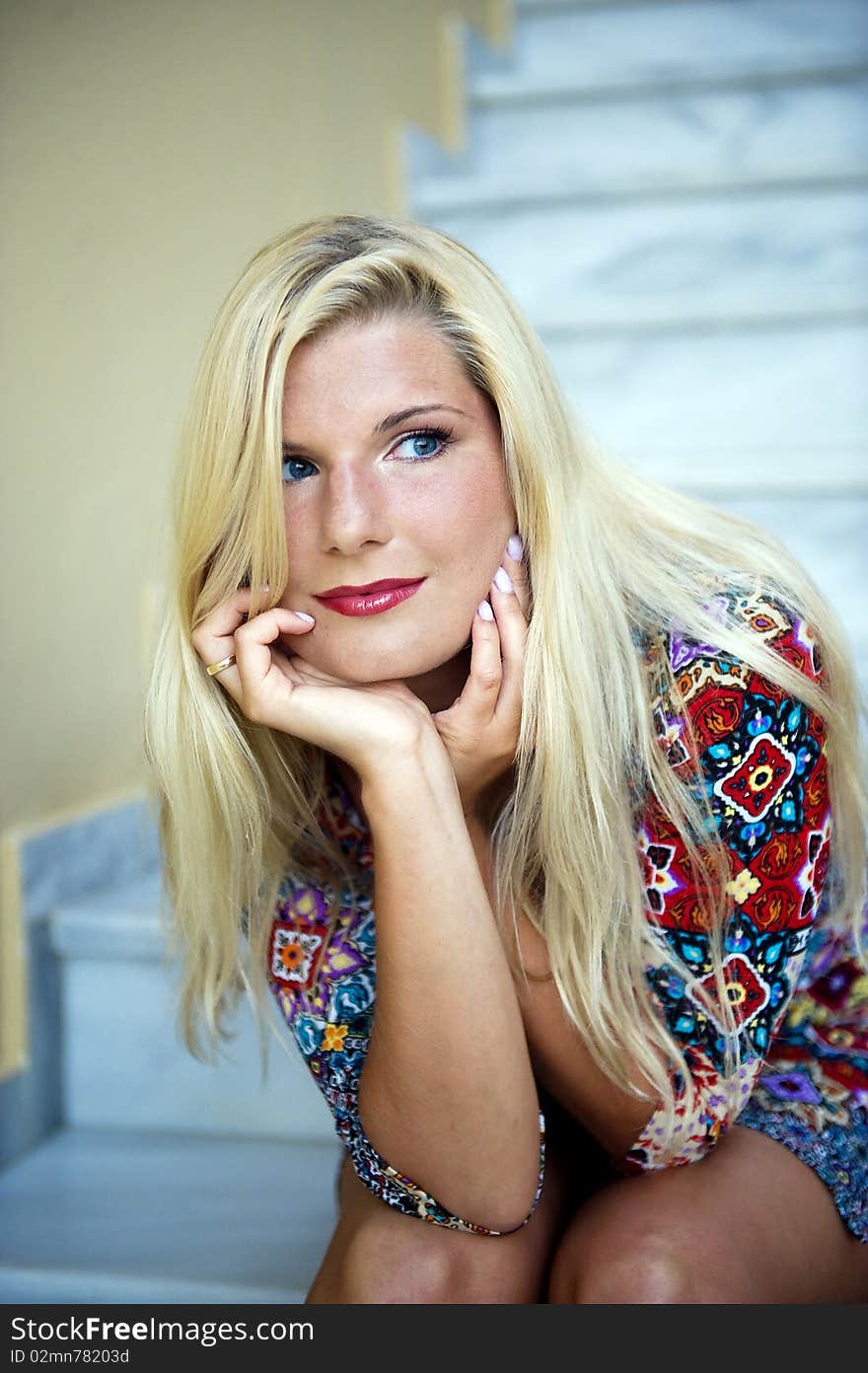 Young beautiful summer womans face sitting on the stairs outdoors