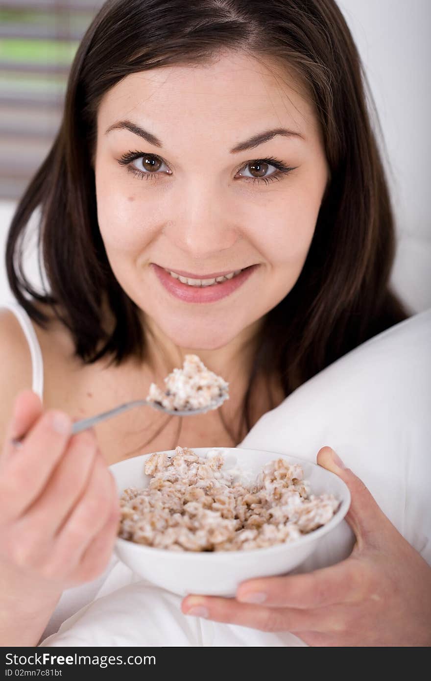 Young adult woman with corn flakes in bed. Young adult woman with corn flakes in bed