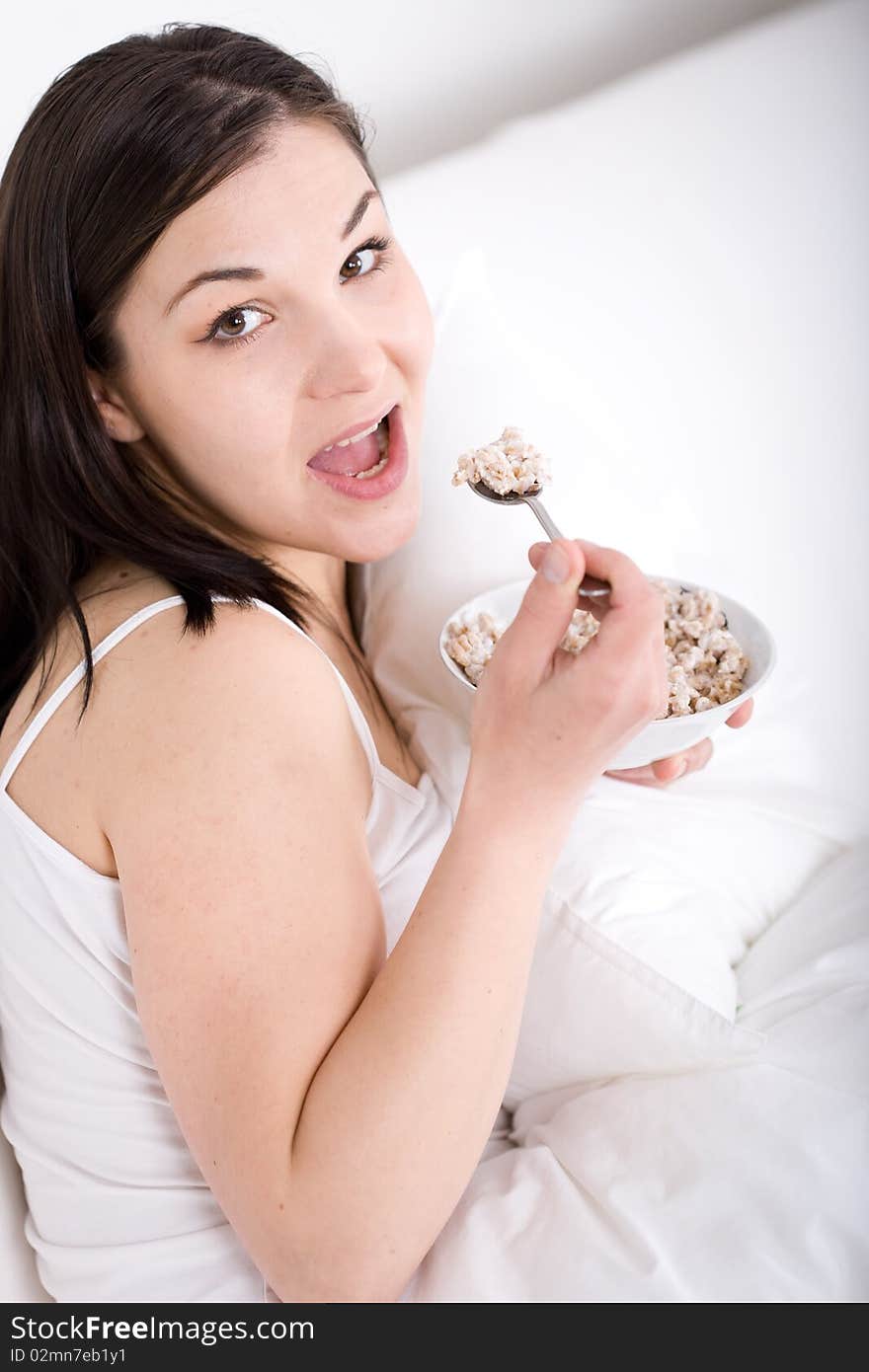 Young adult woman with corn flakes in bed. Young adult woman with corn flakes in bed