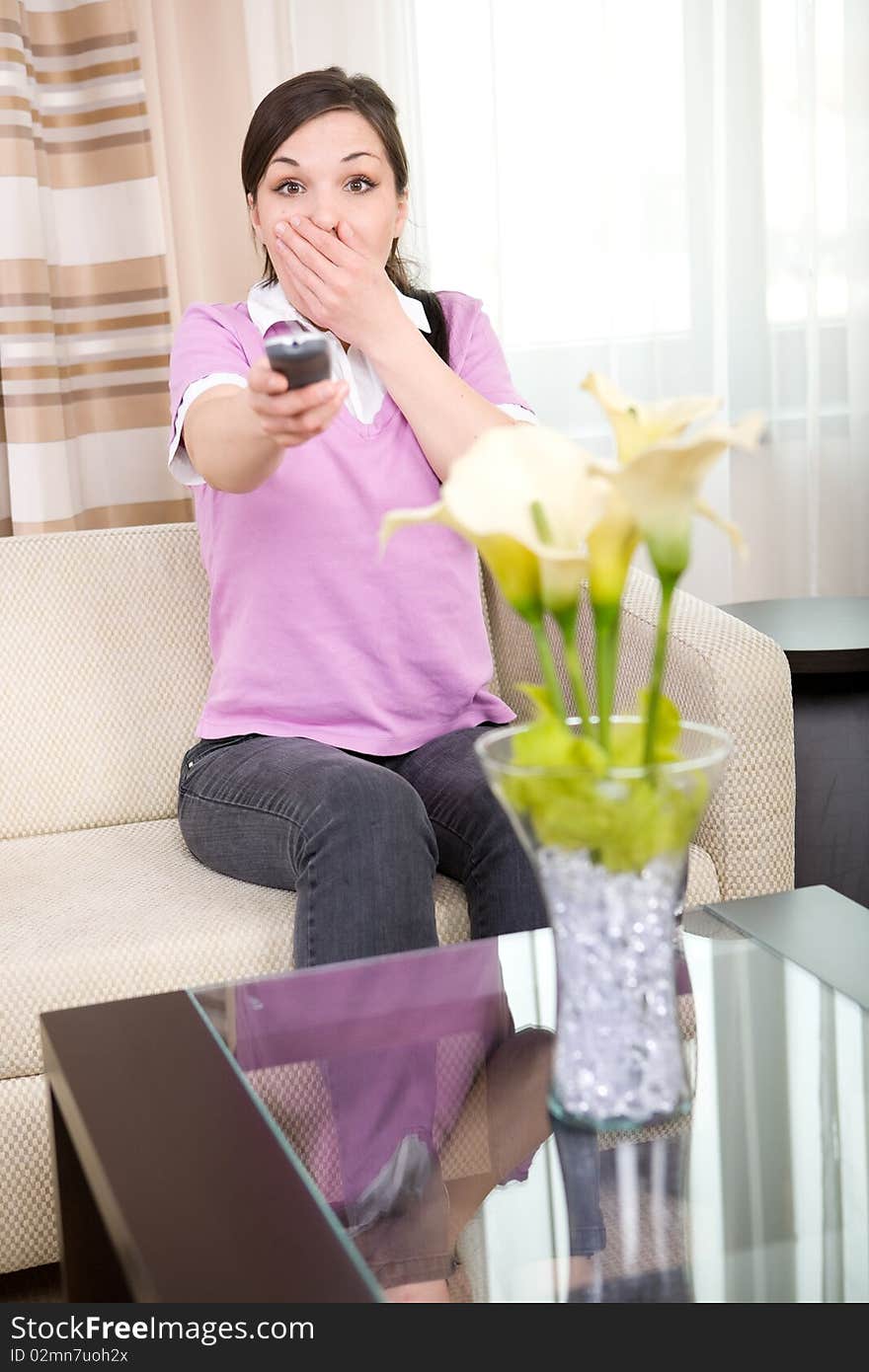 Young adult woman with remote control at home. Young adult woman with remote control at home