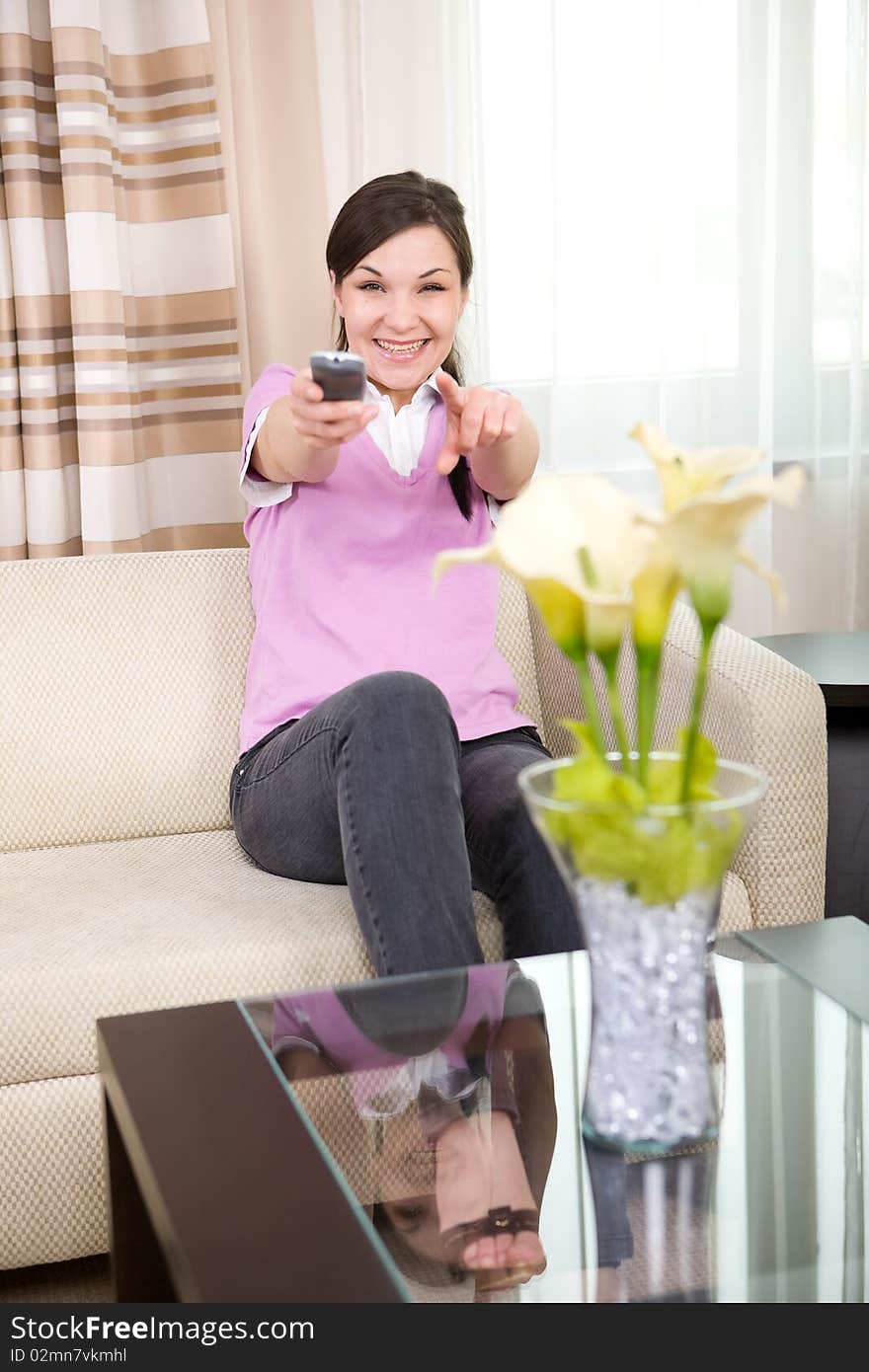 Young adult woman with remote control at home. Young adult woman with remote control at home