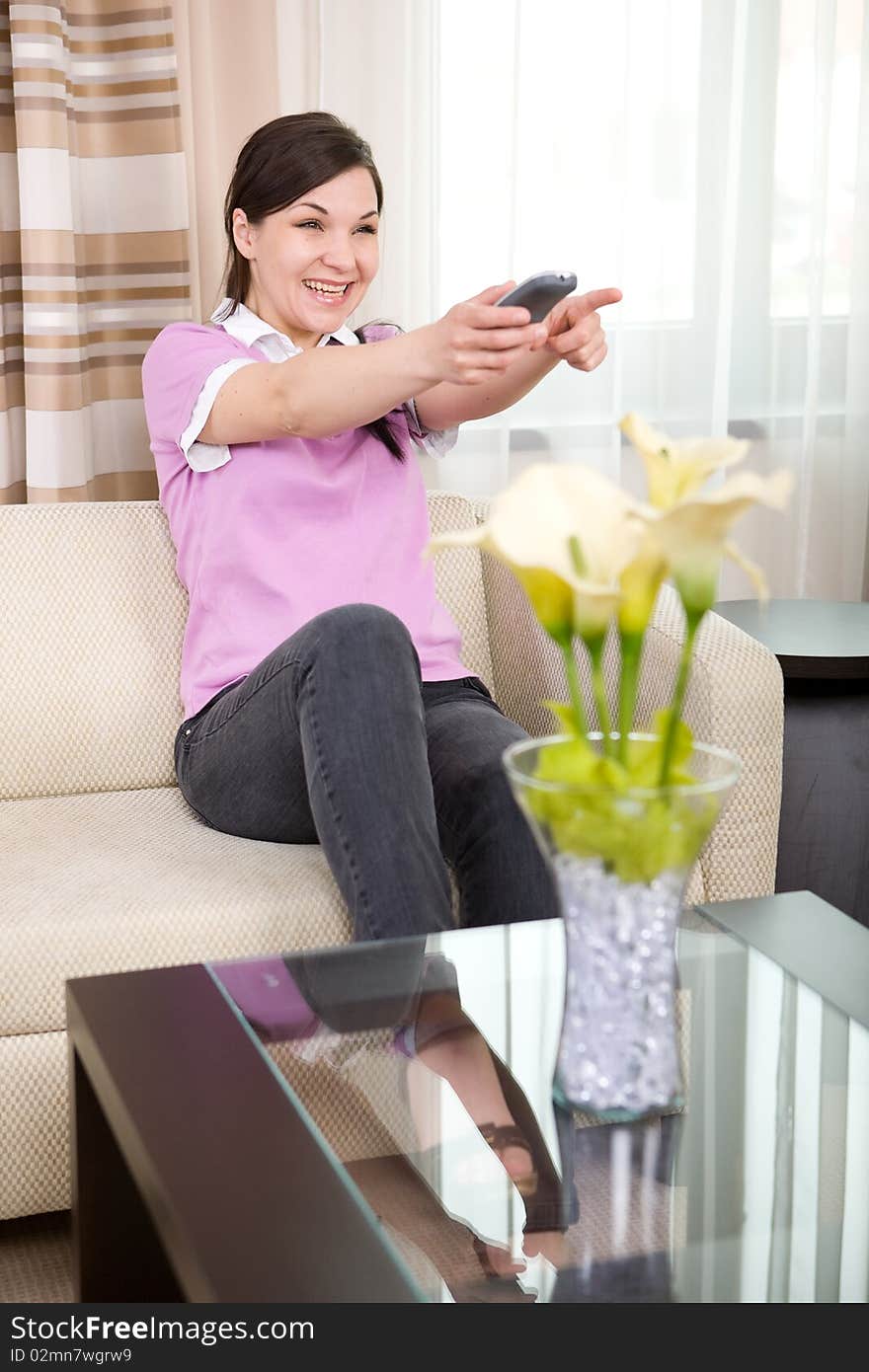 Young adult woman with remote control at home. Young adult woman with remote control at home