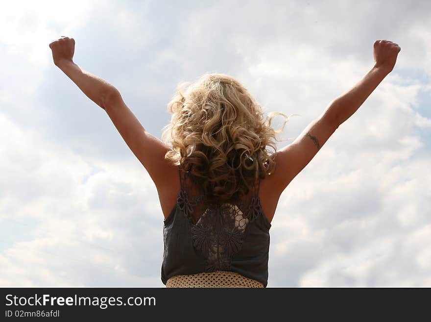 Looks like she is celebrating a victory or success as she looks towards the sky. Looks like she is celebrating a victory or success as she looks towards the sky