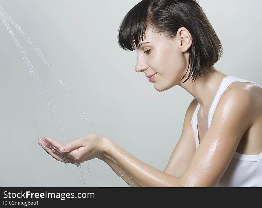 Happy beautiful woman wash her face with pure water. Happy beautiful woman wash her face with pure water