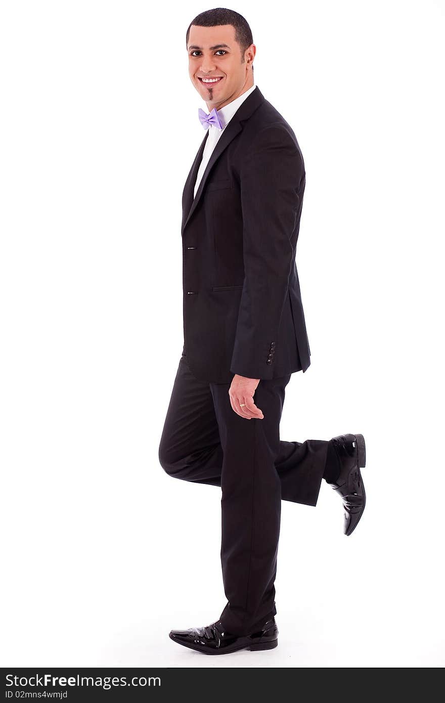 Full length of a business man leaning against the wall on a white isolated background