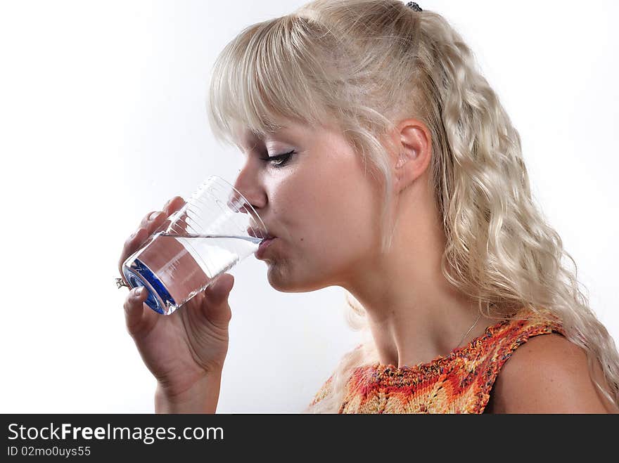 Blond woman drinking a glass of water. Blond woman drinking a glass of water