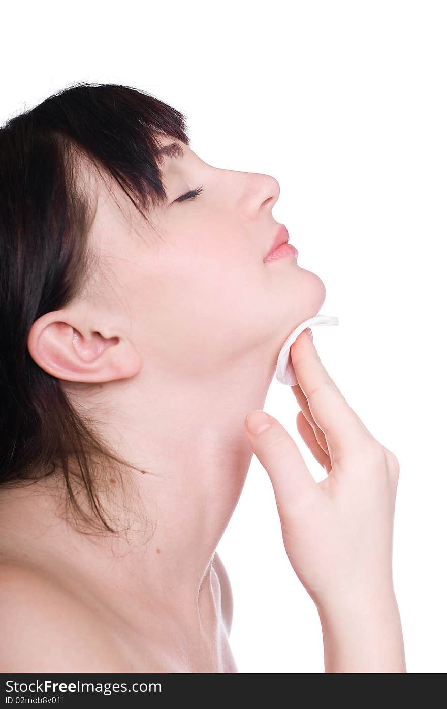 Young woman using a cotton pad to remove her make-up