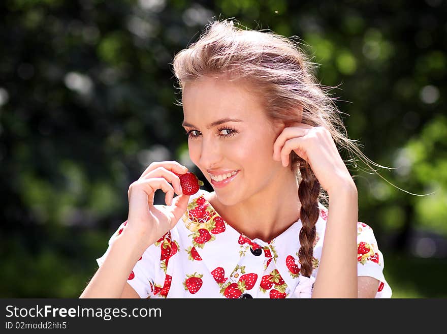 Portrait of the beautiful girl with a strawberry