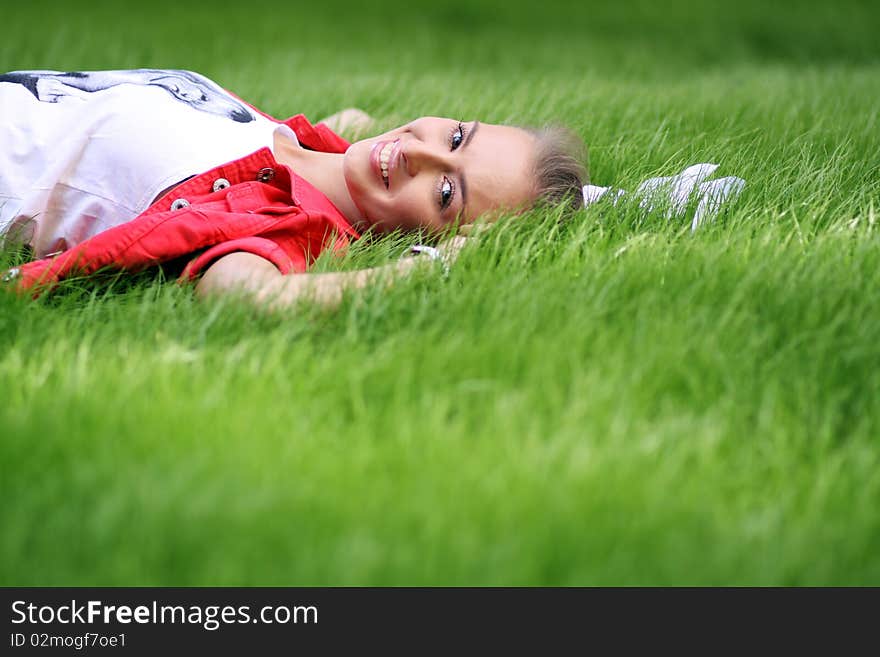 Cute young female lying on grass field at the park. Cute young female lying on grass field at the park