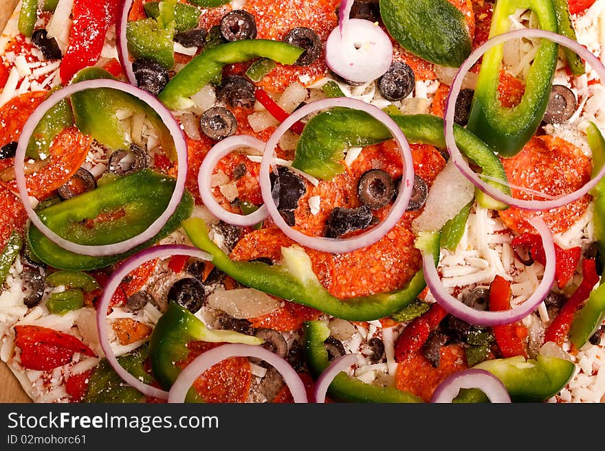 Raw pizza with vegetables and pepperoni