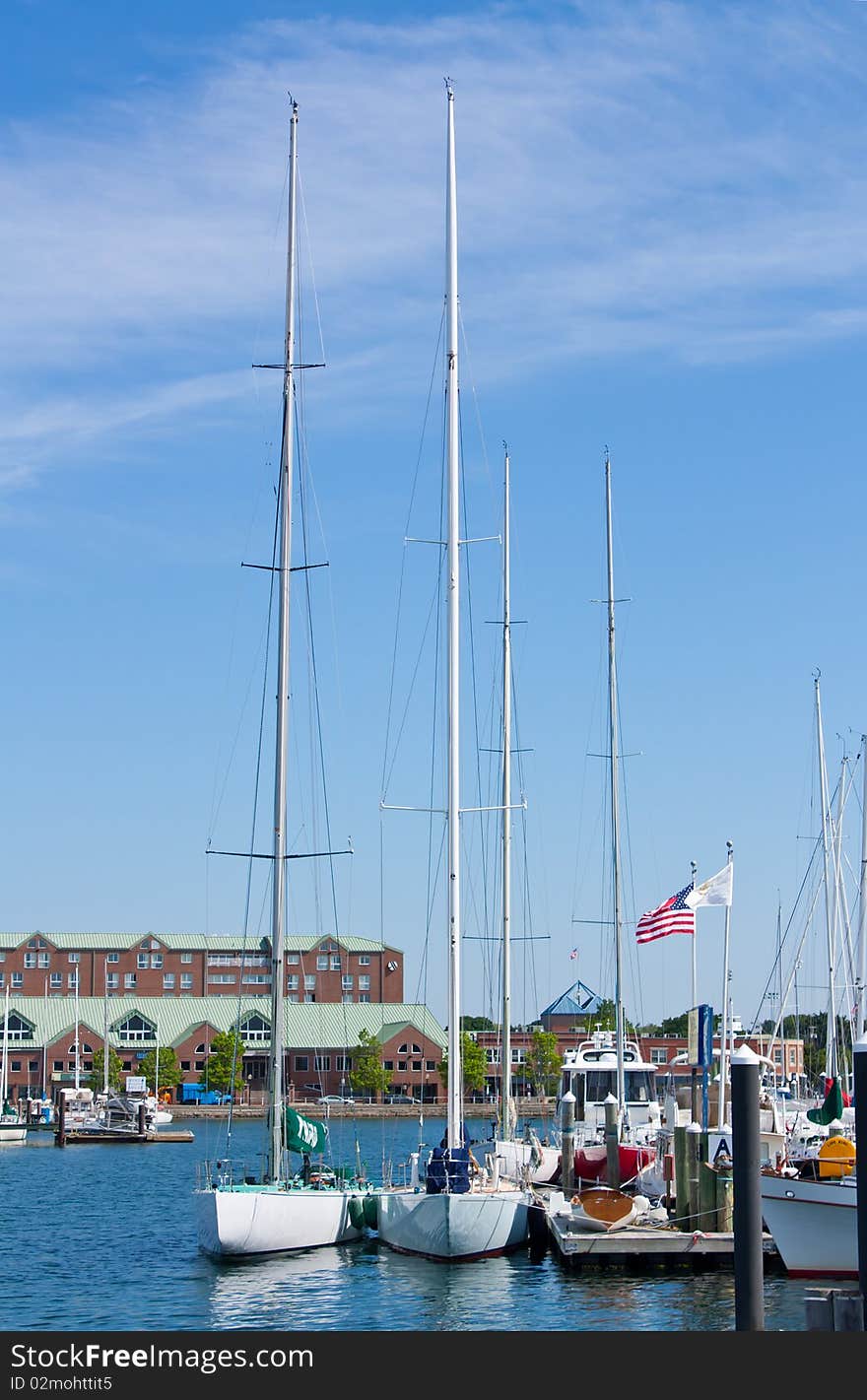 Tall masted sailboats docked in a harbor. Tall masted sailboats docked in a harbor