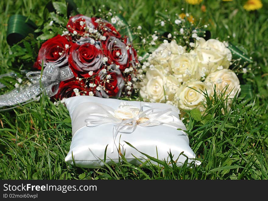 White and red roses bouqet and some rings in the grass. White and red roses bouqet and some rings in the grass.