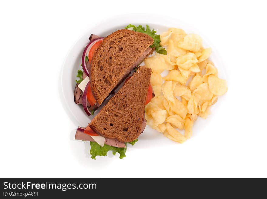 Delicious roast beef sandwich platter with whole wheat bread and potato chips. Delicious roast beef sandwich platter with whole wheat bread and potato chips