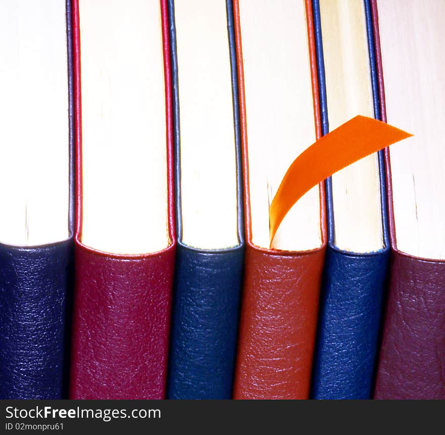 An Orange Bookmark and Six Leather Bound Books