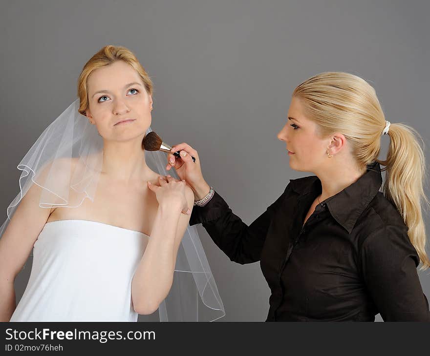 Natural Wedding make-up is being applied to pretty bride. gray background. Natural Wedding make-up is being applied to pretty bride. gray background