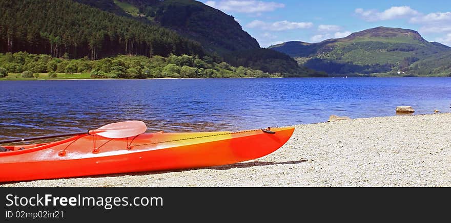 Scenic view of loch lubnaig in scotland  on a warm summers day with a canoe in the foreground. Scenic view of loch lubnaig in scotland  on a warm summers day with a canoe in the foreground