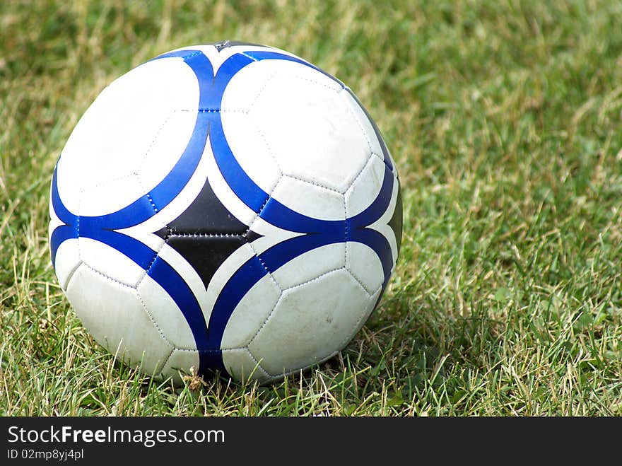 A soccer ball sits on the field of grass. A soccer ball sits on the field of grass.