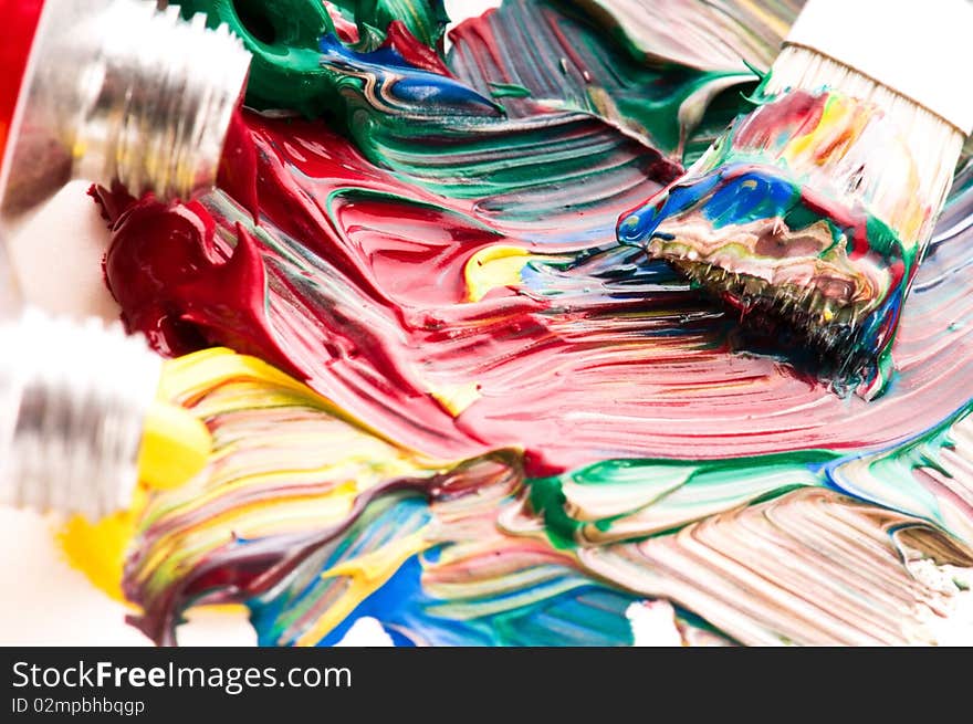 Brush mixing paint on palette. red, yellow, blue, green, white