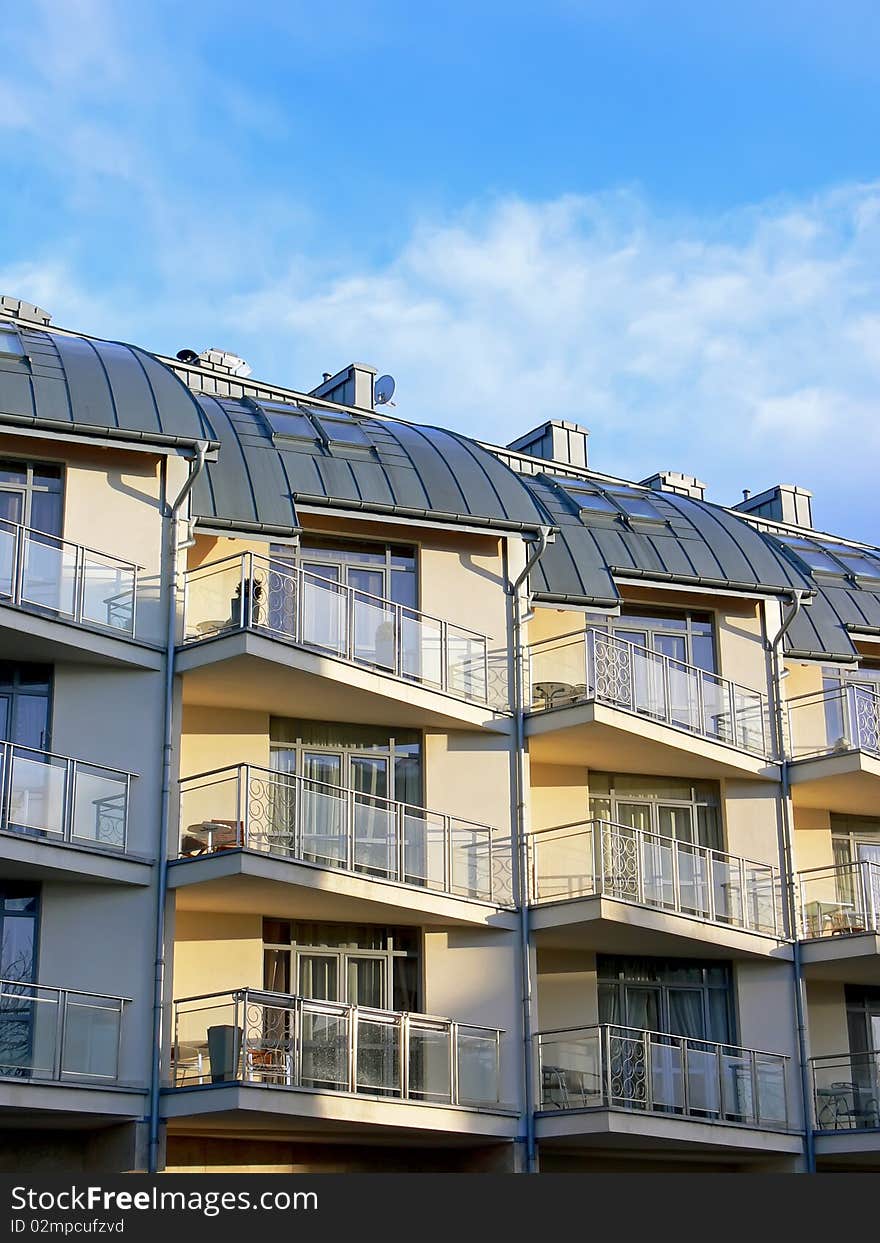 Exterior of modern apartment building with blue sky in the background. Exterior of modern apartment building with blue sky in the background.