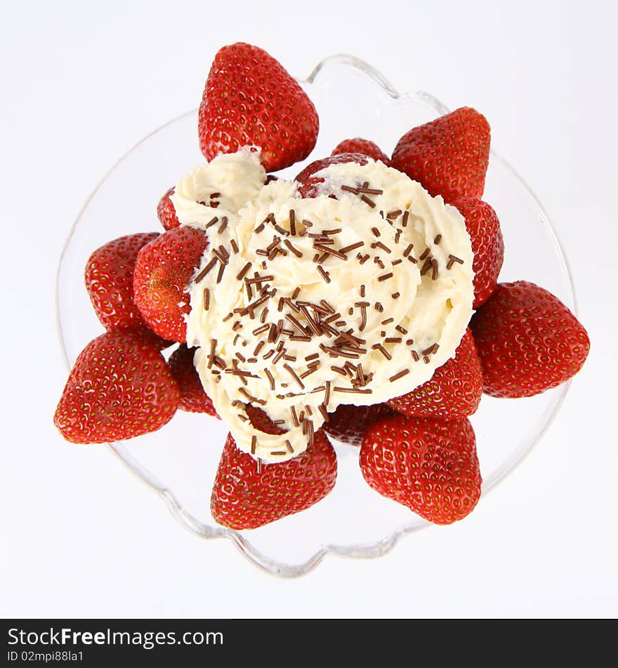 Strawberries in a glass cup with whipped cream and chocolate sprinkles in close up. Strawberries in a glass cup with whipped cream and chocolate sprinkles in close up