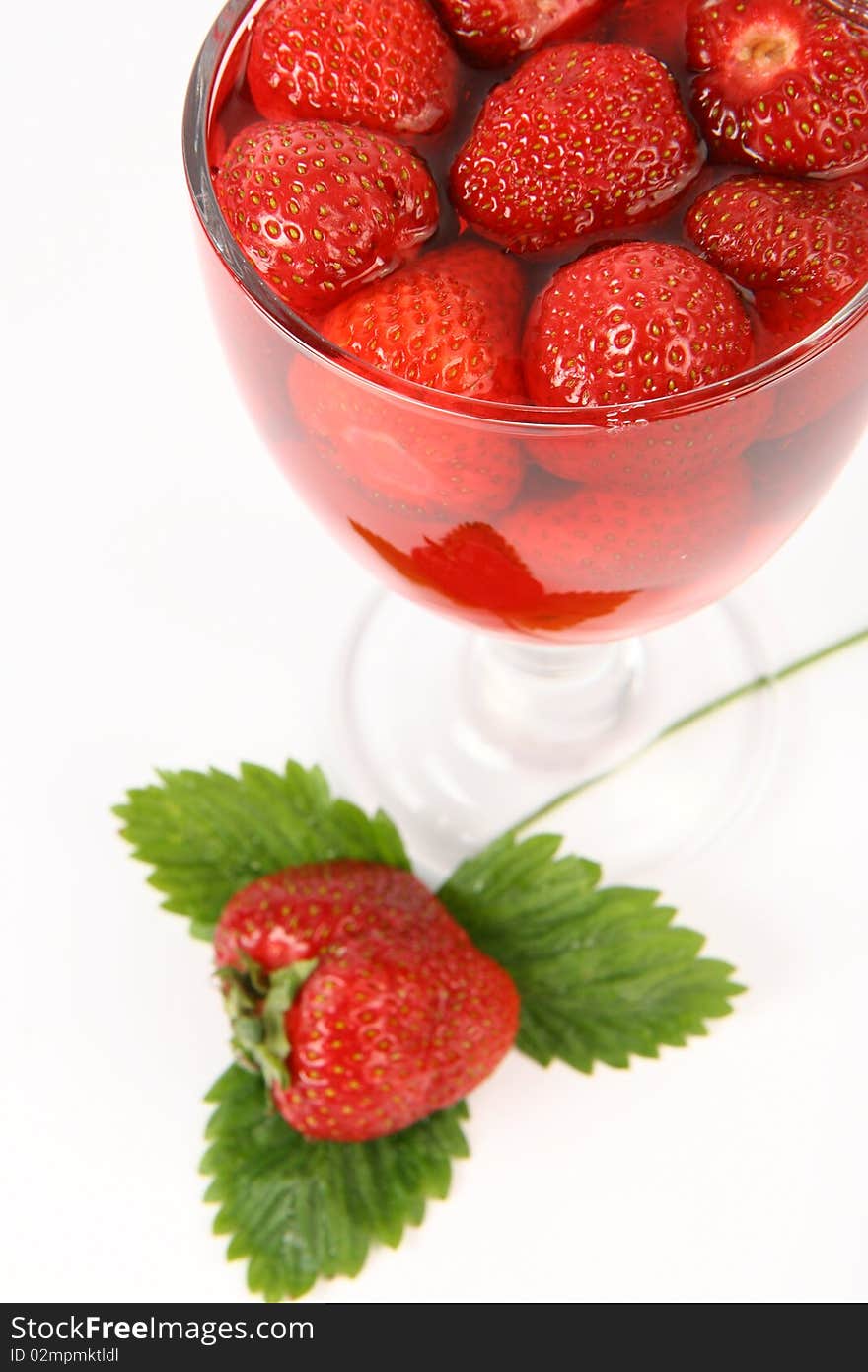 Jelly with strawberries decorated with a strawberry on a leaf in a cup