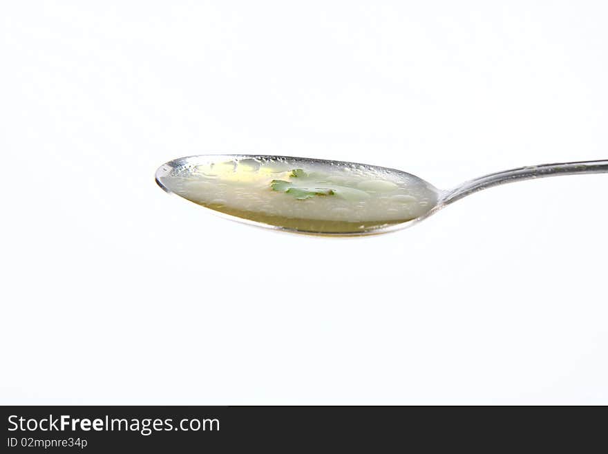 Chicken soup decorated with parsley on a spoon. Chicken soup decorated with parsley on a spoon