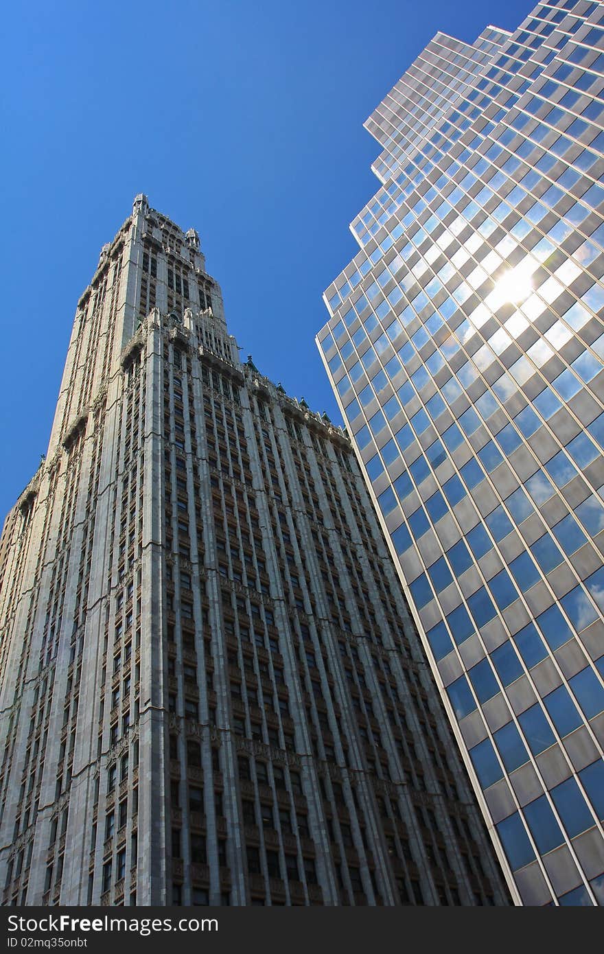 Two skyscrapers of different eras are proudly standing under the New York sun. Two skyscrapers of different eras are proudly standing under the New York sun.