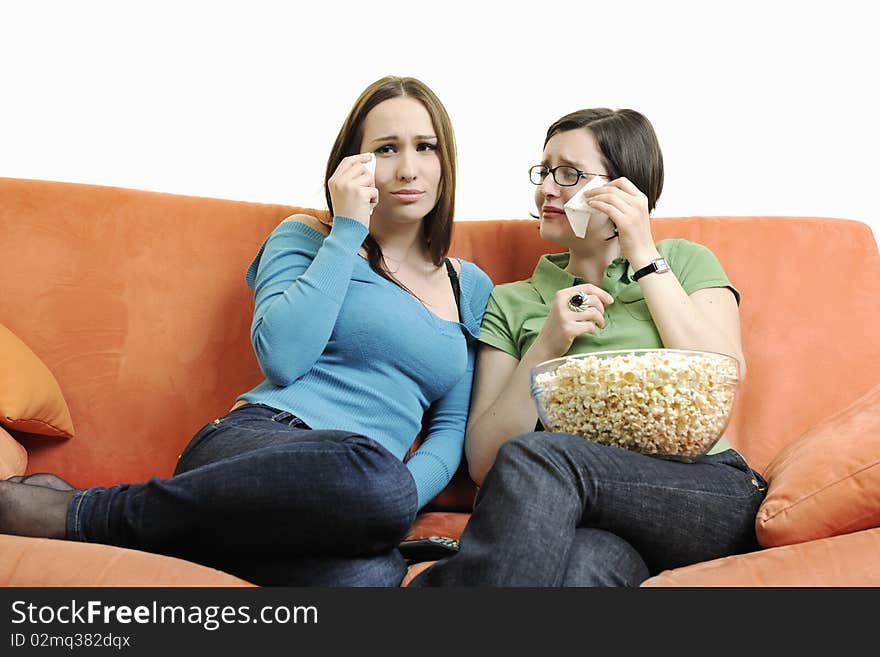 Two happy girls play game with hands isolated on white or orange sofa. Two happy girls play game with hands isolated on white or orange sofa