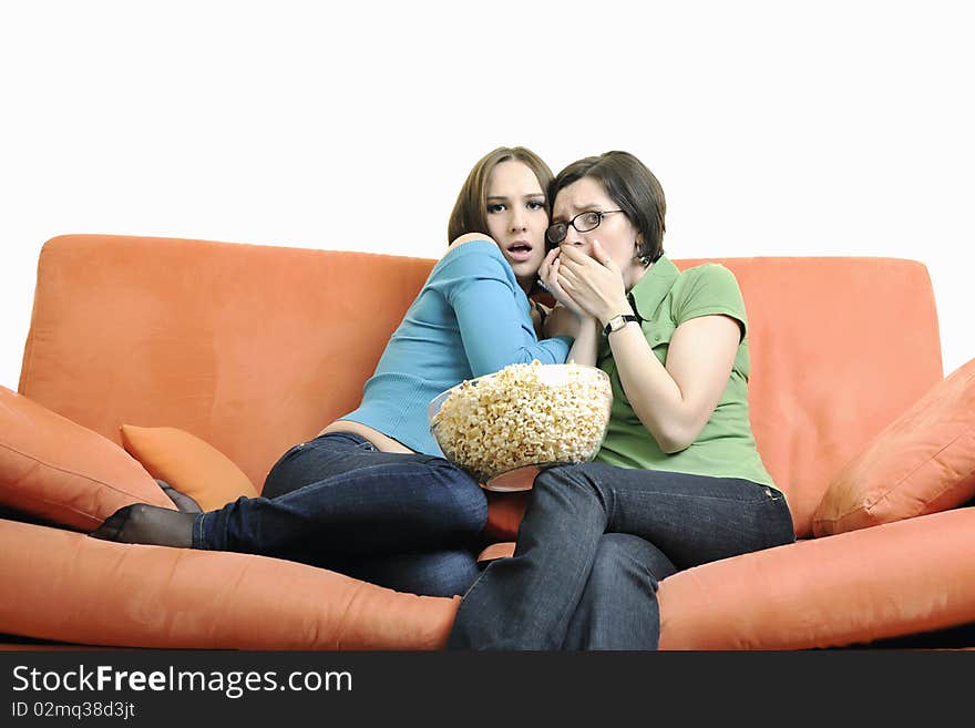 Two happy girls play game with hands isolated on white or orange sofa. Two happy girls play game with hands isolated on white or orange sofa