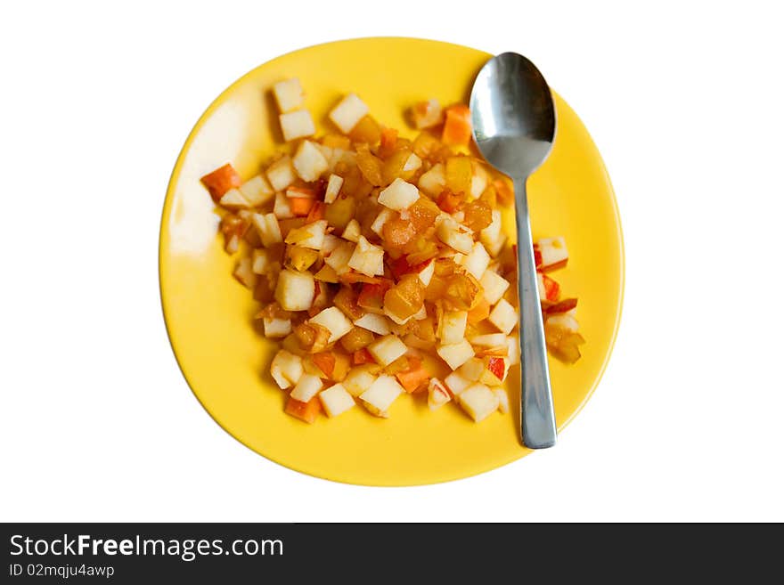 Fruit salad on yellow plate with a spoon isolated on white. Fruit salad on yellow plate with a spoon isolated on white