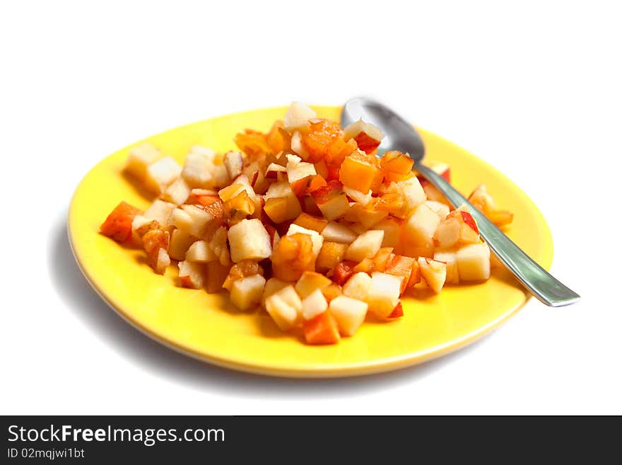 Fruit salad on yellow plate with a spoon isolated on white. Fruit salad on yellow plate with a spoon isolated on white