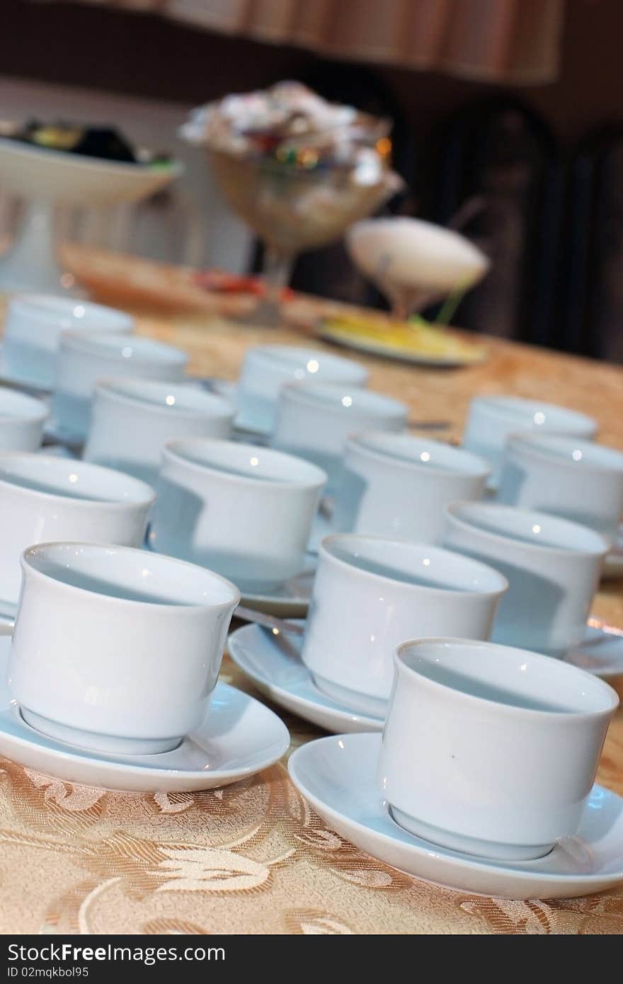 A lot of white cups for coffee or tea on a table