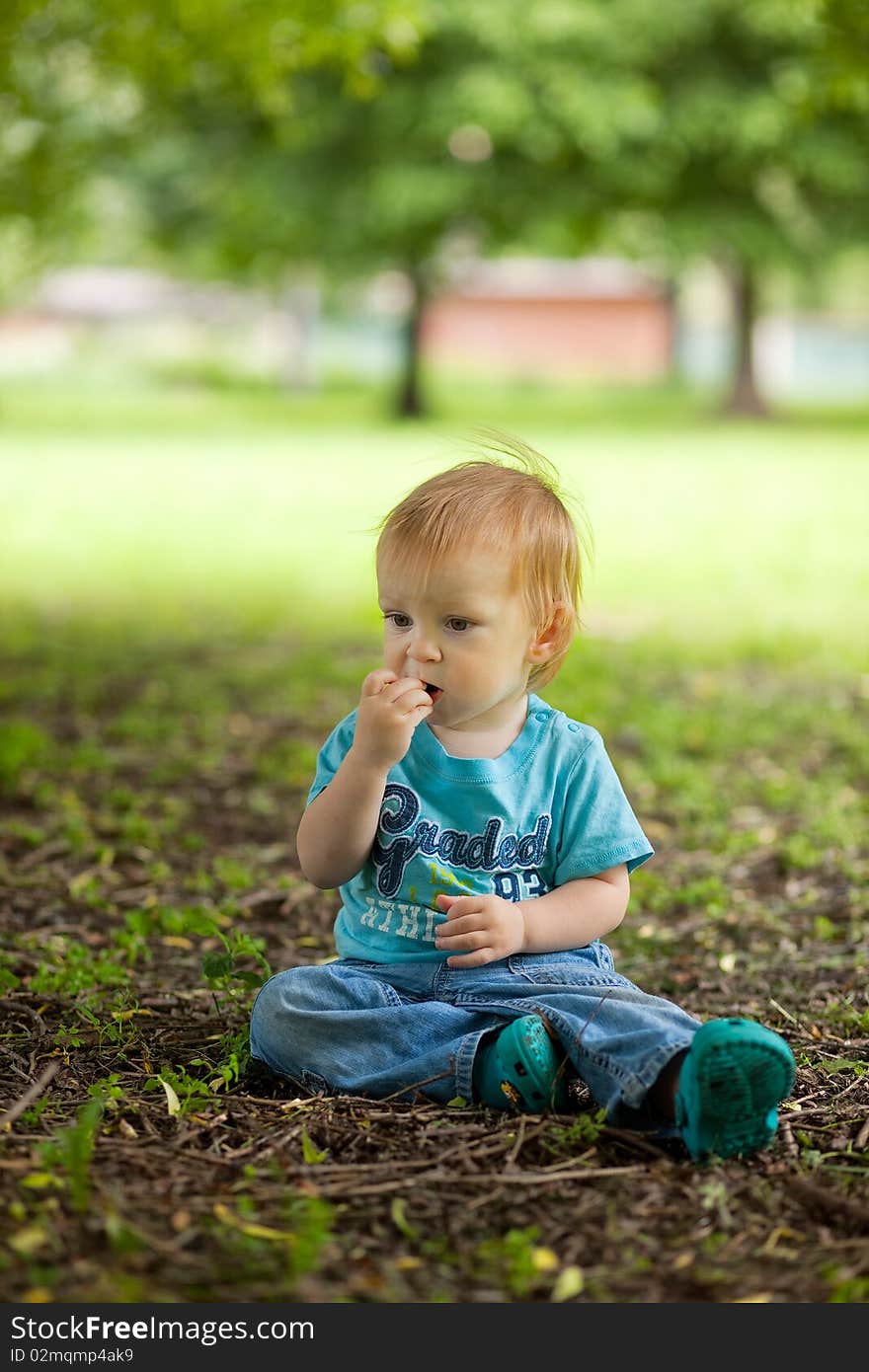 Cute little boy sitting on the ground