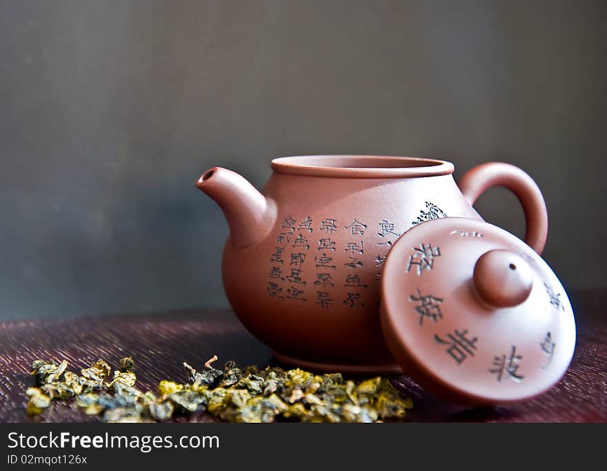 Chinese teapot and tea leaf on wooden table
