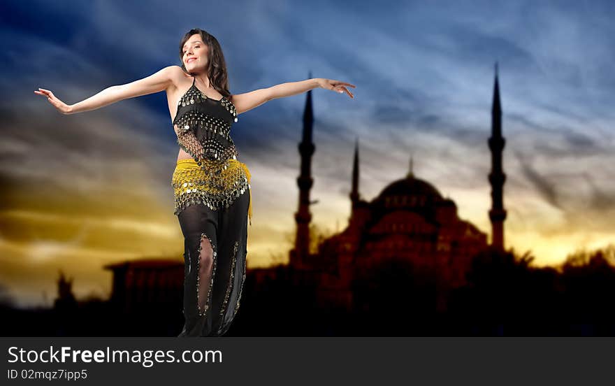 Portrait of a beautiful woman in arabic clothes dancing with mosque on the background. Portrait of a beautiful woman in arabic clothes dancing with mosque on the background