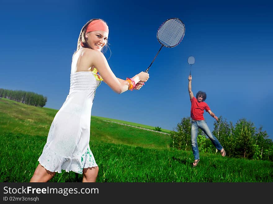 Boy and nice girl with rackets on field