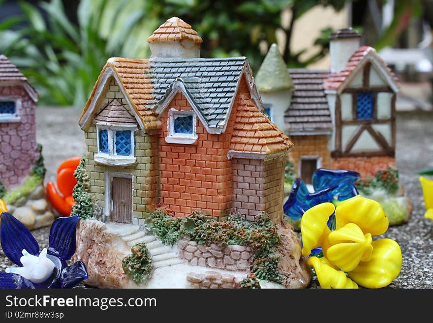 Picture of miniature houses surrounded by glass flowers.