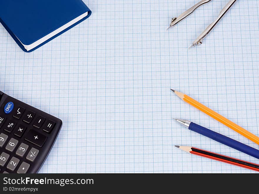 Book, calculator and pens at paper